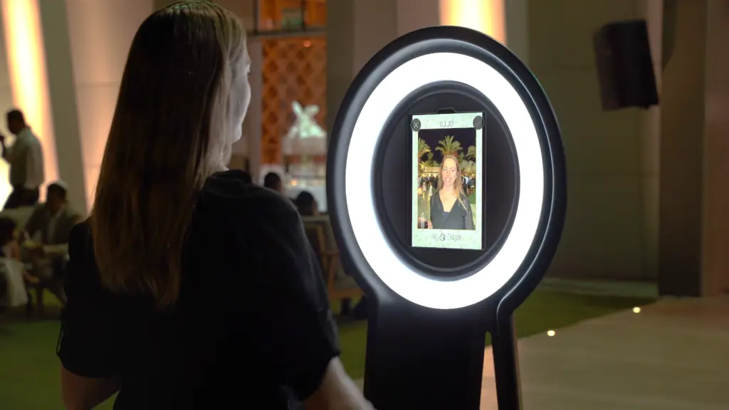 A woman reviewing her selfie taken on the Pylon Parti-Pixel Photo Booth at a venue